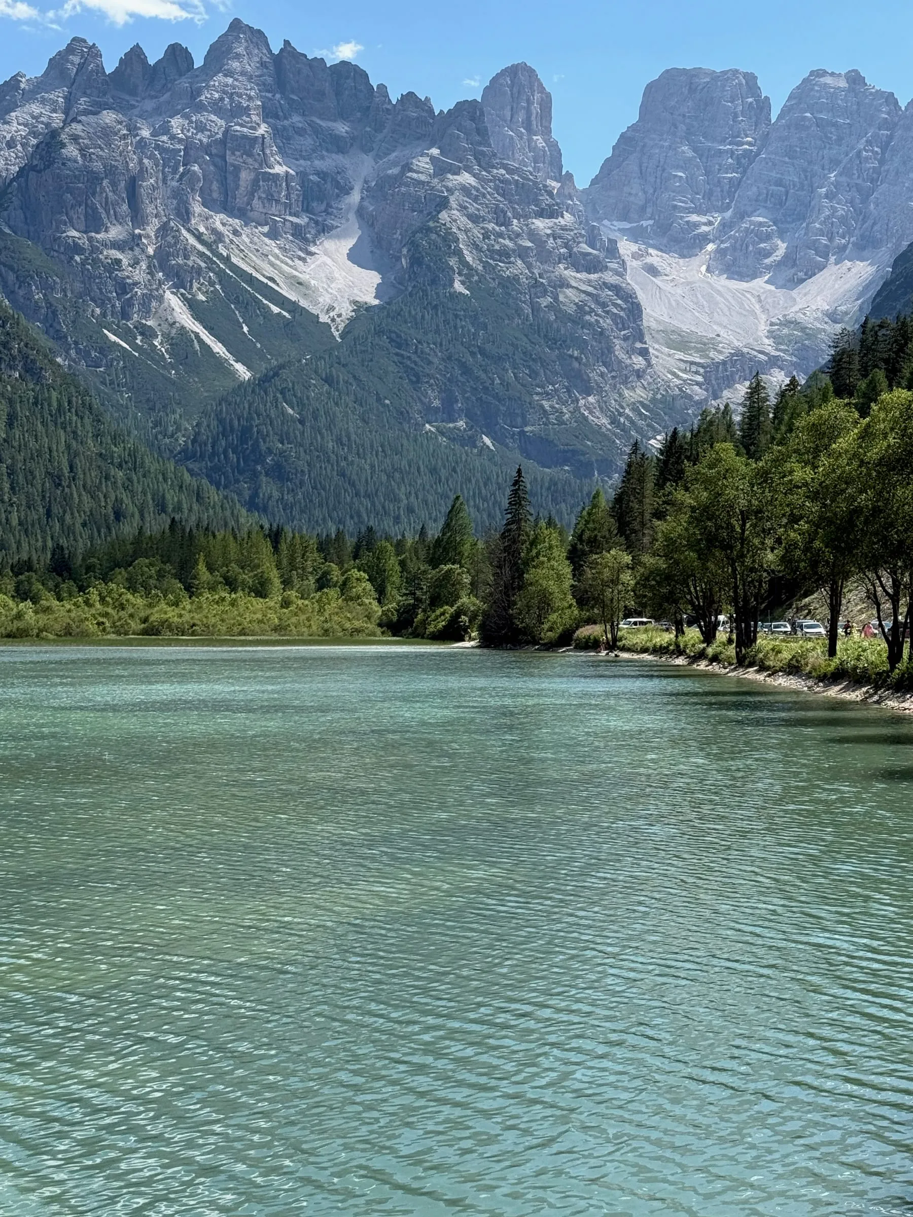 Lago di Landro, pale green water below a wall of grey Dolomite peaks